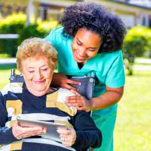 senior woman on a wheelchair and her caregiver